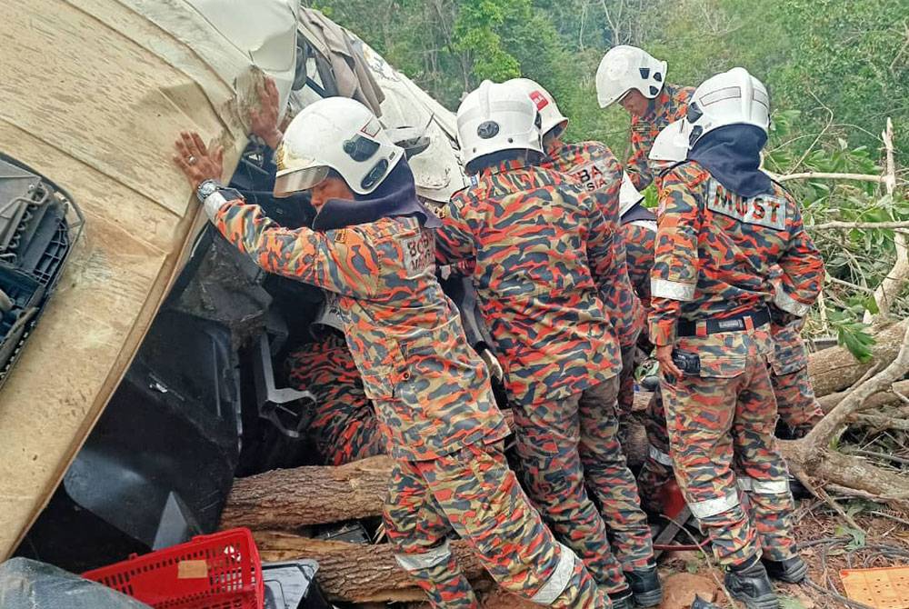 Pasukan bomba dari BBP Gerik menjalankan operasi mengeluarkan seorang mangsa tersepit dalam treler. Foto bomba