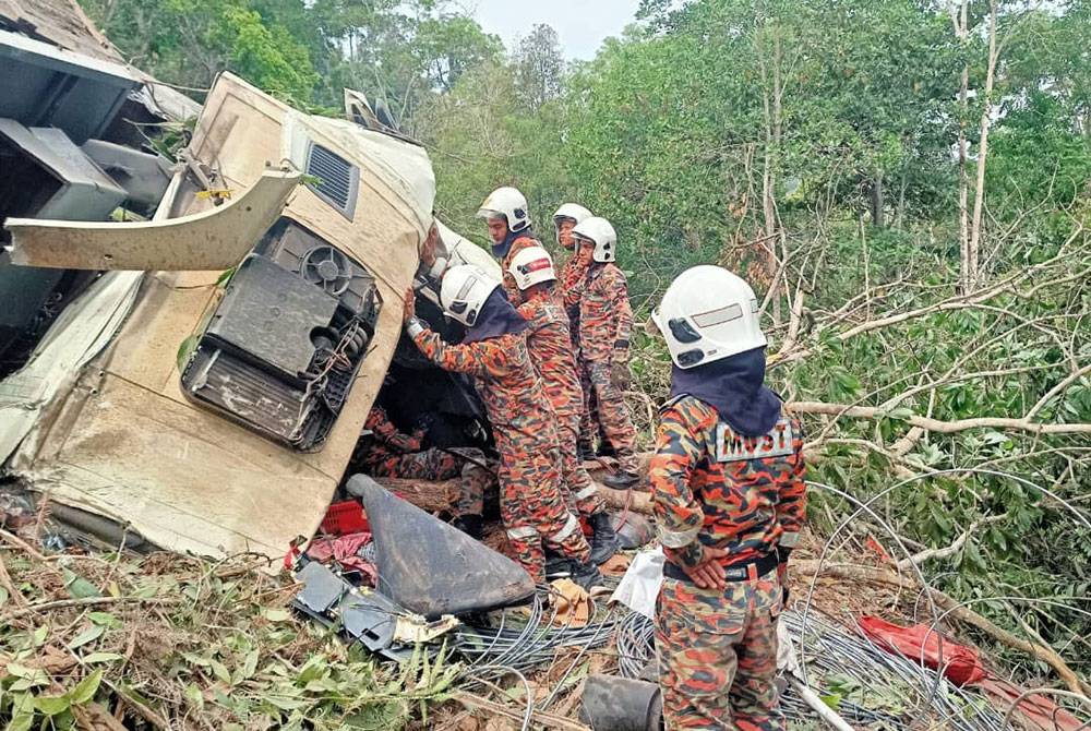 Sebuah treler muatan besi terbabas ke gaung menyebabkan dua lelaki cedera di Gerik. Foto bomba