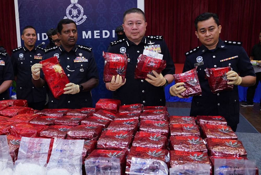 Kok Chin (tengah) menunjukkan antara bungkusan dadah jenis syabu yang dirampas susulan serbuan sebuah rumah di Lembah Klang pada Rabu.