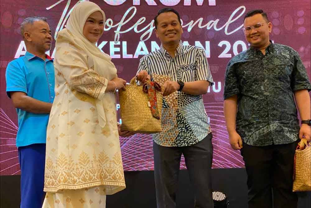 Nik Nazmi (dua dari kanan) menyampaikan cenderamata kepada Selebriti dan Usahawan, Datuk Nora Ariffin yang menjadi panel pada Forum Profesional Anak Kelantan 2024 di Kota Bharu pada Sabtu.