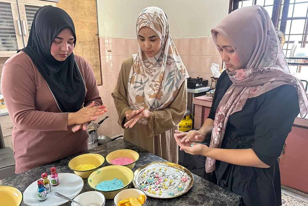 Proses membentuk Bua Loy menjadi bunga dilakukan Nur Nadira (tengah) bersama dua pekerjanya.