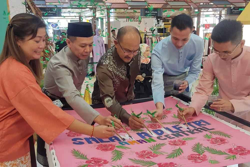 Mohd Salleh (tengah) menyempurnakan gimik pelancaran Perasmian Dekorasi Salam Aidilfitri Aman Central pada Jumaat. Turut kelihatan Ken Chin (dua kiri).