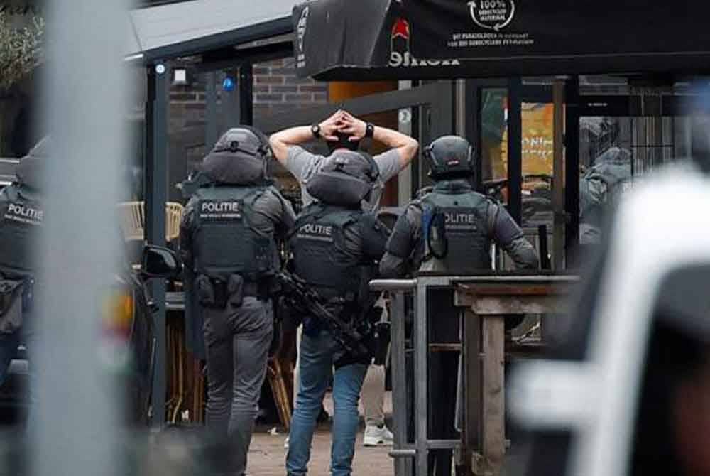 Suspek meninggalkan kafe itu dengan mengangkat tangannya dan ditahan polis di luar venue. - Foto Reuters