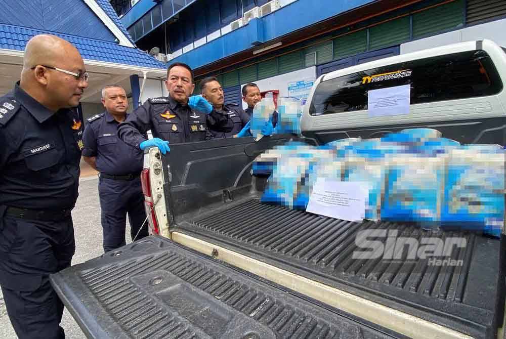 Muhamad Zaki (dua dari kiri) menunjukkan beras yang dirampas.