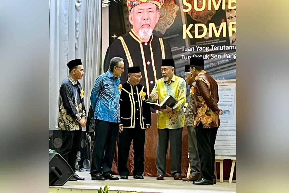 Juhar (tiga dari kanan) bersama wakil Kumpulan Karangkraf, Muhammad Nasir (dua dari kanan) dan Ahmad Yani (kanan) selepas menghadiri Majlis Pelancaran Terjemahan Al-Quran Dusun dan Penterjemahan Empat Bahasa Etnik di Kota Kinabalu.
