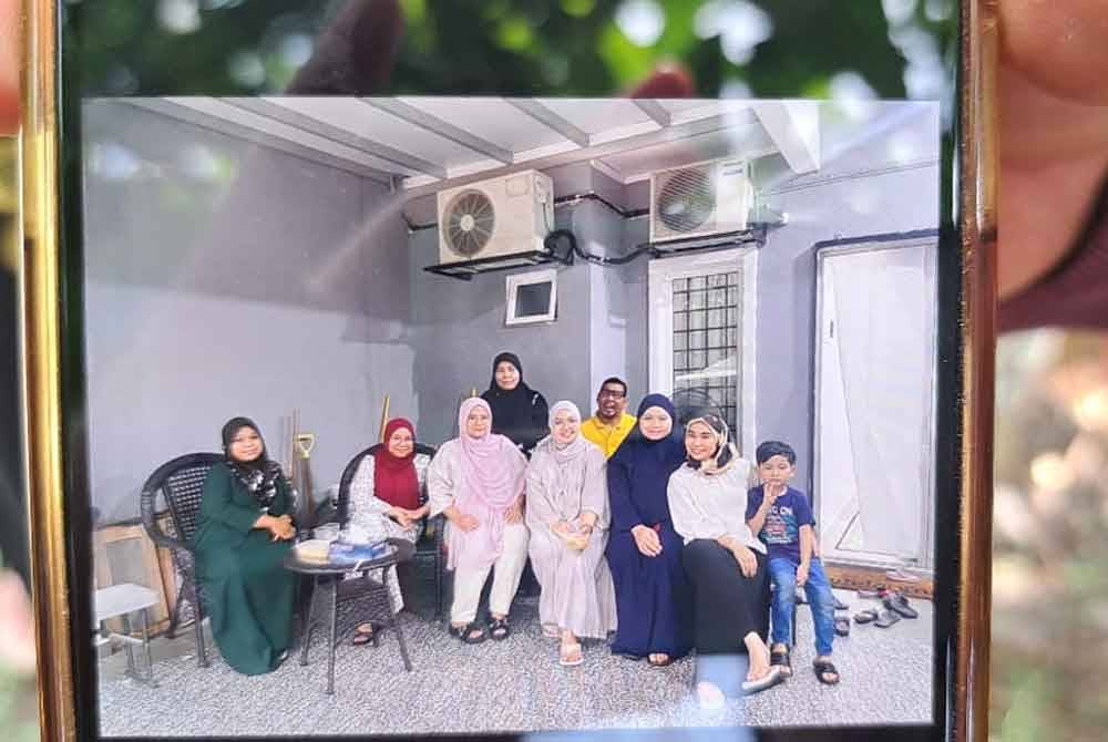 Allahyarham Manirah (berdiri, tudung hitam) bergambar bersama keluarganya.