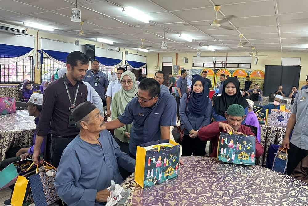 Badrul Hisham (dua dari kiri) turut mengagihan sumbangan kuih raya kepada penghuni di RSK.
