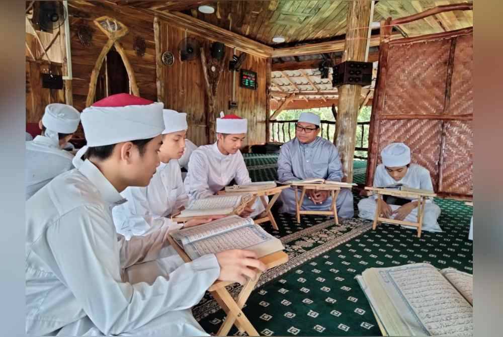 Mohd Fikri (dua dari kanan) melihat melihat pelajar Maahad Tahfiz Al-Quran Darul Quwwah, Pasir Tumbuh bertadarus.