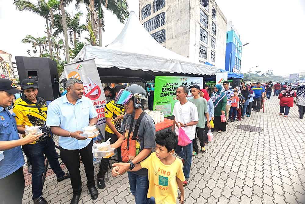 Arul Kumar turut mengagihkan lemang dan bubur lambuk percuma kepada orang ramai