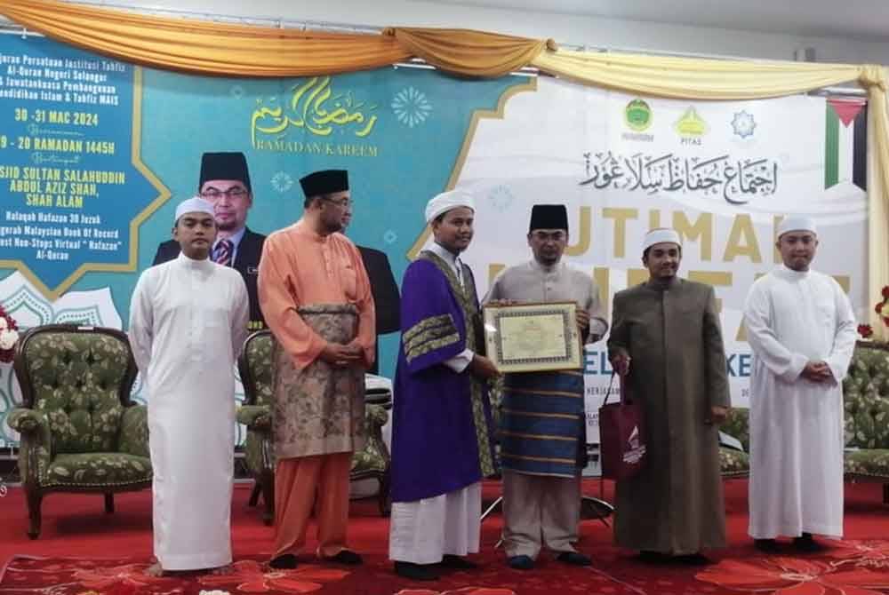 Mohd Shahzihan menyampaikan sijil syahadah 30 juzuk PITAS kepada salah seorang penerima.
