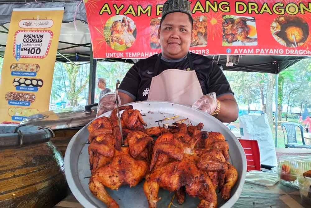 Muhammad Muslim menunjukkan ayam payang dragon yang siap dipanggang dan sedia untuk dijual kepada pelanggan.