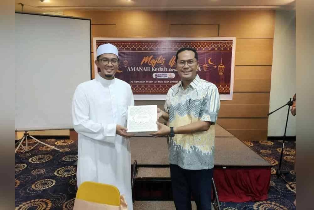 Mohd Asmirul (kanan) menerima cenderahati daripada Pengarah Komunikasi Amanah Kedah, Firdaus Shater selepas Majlis Iftar bersama Media dan Rakan Strategik Amanah Kedah di sebuah hotel pada Ahad.