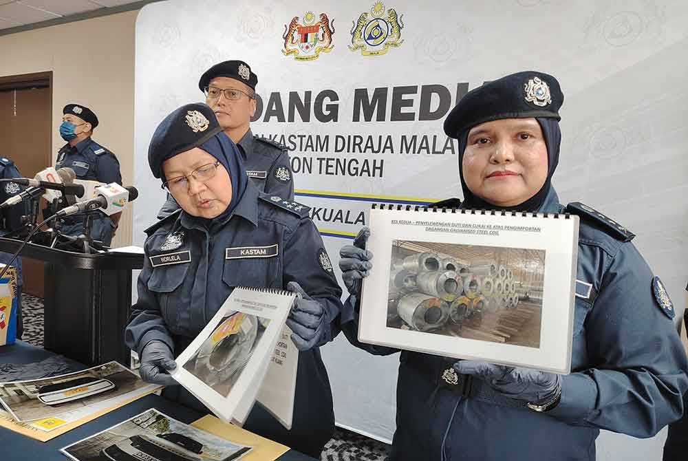 Norlela (kiri) melihat paparan gambar gelung besi yang dirampas pihaknya dalam serbuan di sebuah gudang di Pelabuhan Klang, 19 Mac lalu.