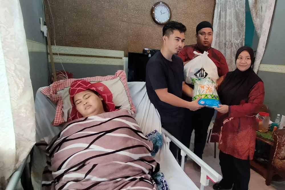 Muhammad Mazwan menerima sumbangan dari Madad Care ketika melakukan kunjungan ke rumah mereka.