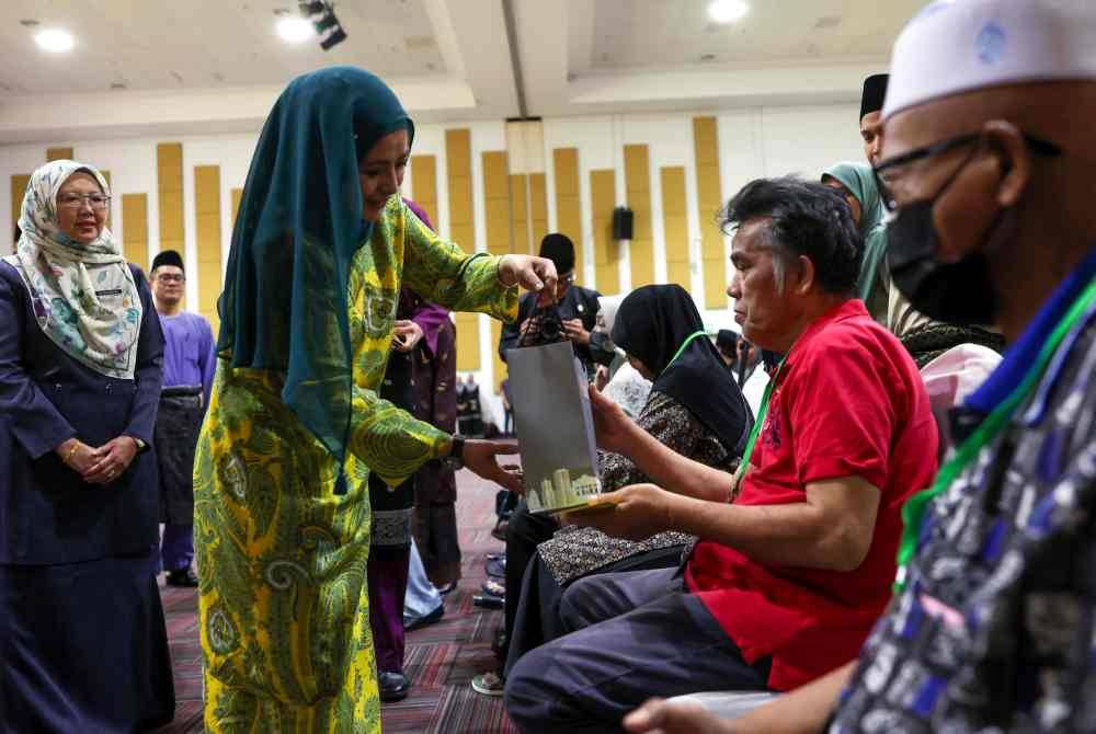 Raja Zarith Sofiah (dua dari kiri) menyampaikan sumbangan kepada golongan asnaf pada Majlis Sumbangan Aidilfitri Komuniti Wilayah Persekutuan Kuala Lumpur 2024 di Institusi Latihan Dewan Bandaraya Kuala Lumpur (IDB) Bandar Tun Razak pada Isnin. Foto Bernama