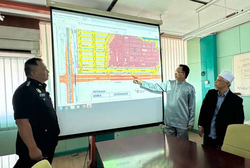 Mohd Anis (dua dari kanan) menunjukkan peta lokasi stesen sementara bagi bas sewaan khas menurun dan menaikkan penumpang.