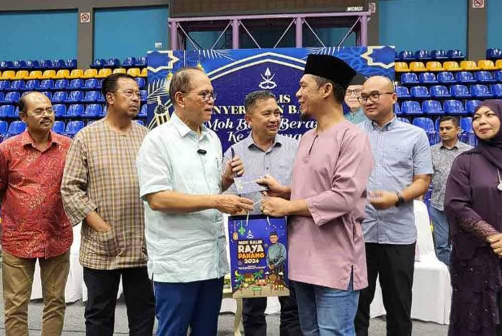 Wan Rosdy (tiga dari kiri) menyampaikan bantuan kepada salah seorang penerima di Stadium Titiwangsa pada Ahad.