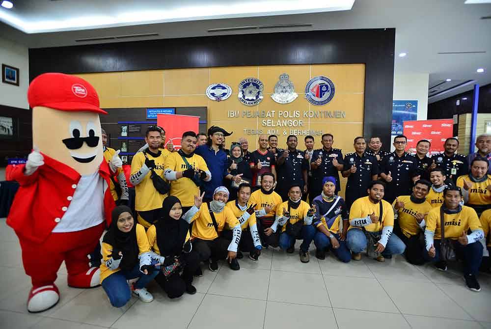 Penghantar makanan bergambar bersama anggota polis di Ibu Pejabat Polis Kontinjen Shah Alam.