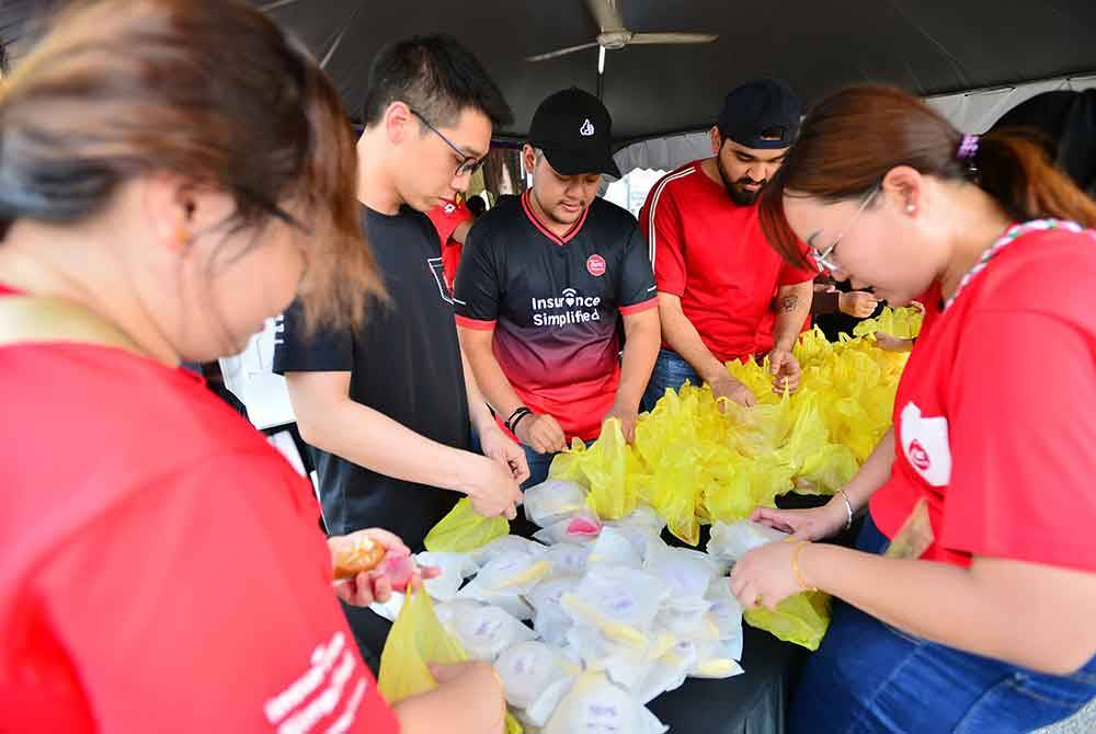 Kakitangan Tune Protect berada di perkarangan Kompleks Karangkraf Shah Alam bagi membantu dalam pembungkusan dan penyediaan makanan untuk diedarkan kepada golongan sasar.