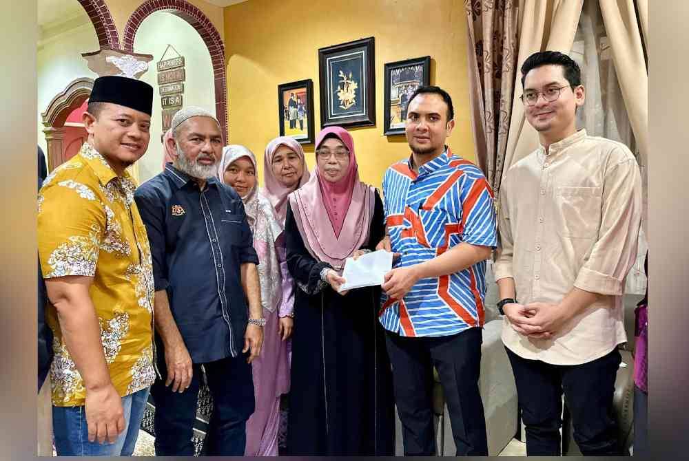 Sumbangan disampaikan Setiausaha Politik Anwar, Farhan Fauzi kepada isteri Allahyarham, Che Gayah ketika sesi ziarah semalam. Foto Facebook Anwar Ibrahim.