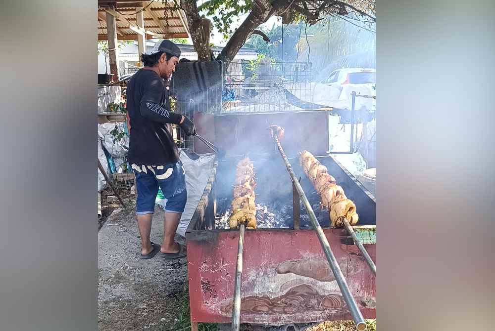 Salah seorang pekerja sedang membakar ayam golek