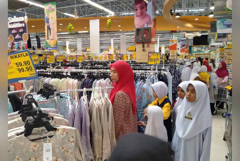 Murid-murid SK Raja Perempuan Ipoh turut teruja memilih pakaian baharu sumbangan DPMP di Pasar raya Besar Mydin Meru di sini pada Isnin.