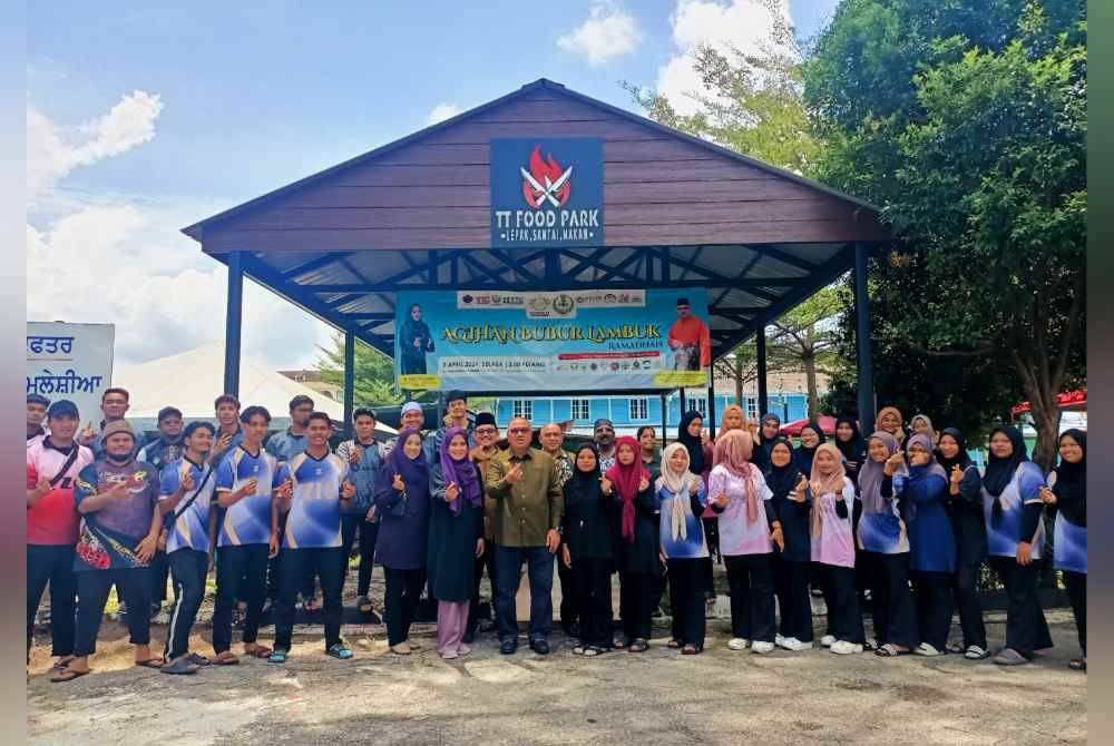 Mohd Zolkafly (tengah) bersama sebahagian pelajar TIC sempena program agihan bubur lambuk anjuran TT Group bersama gabungan 10 pertubuhan bukan kerajaan (NGO) pada Selasa.