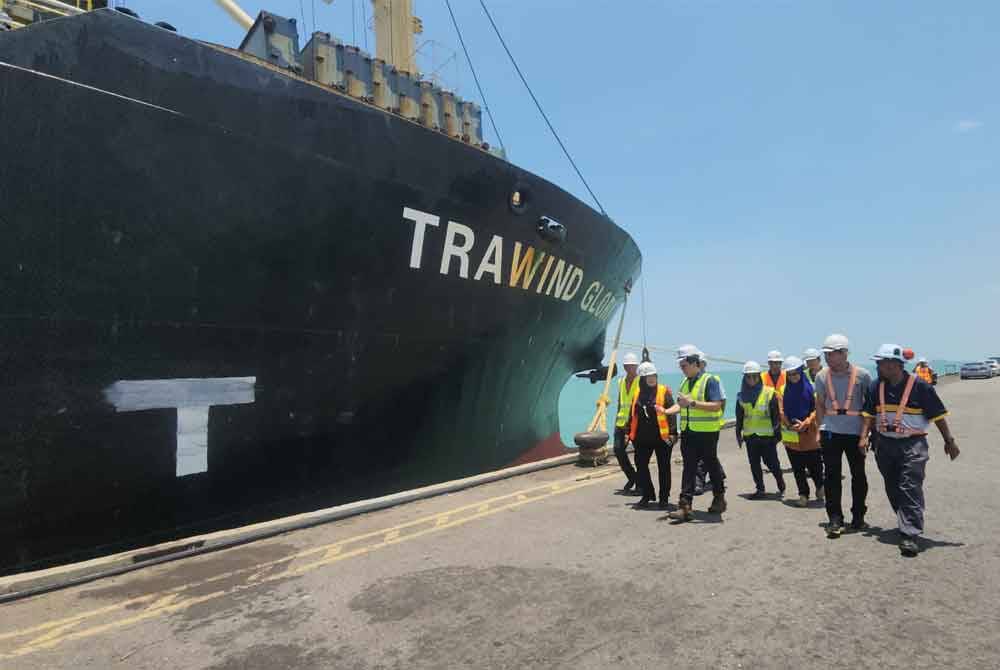 Tuminah (dua dari kiri) ketika meninjau kerja-kerja pemunggahan hampas sawit ke dalam kapal kargo di Pelabuhan Tanjung Beruas, Tanjung Kling pada Selasa.