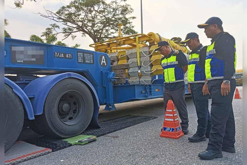 Lokman (depan) melihat pemeriksaan sebuah lori di Kawasan Rehat & Rawat (RNR) Pandan, Lebuhraya EDL, Johor Bahru, pada Selasa