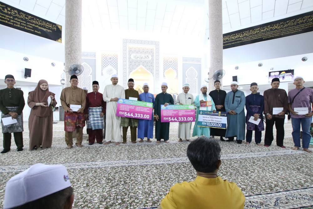 Mohamad (tengah) menyerahkan replika jumlah wang yang disalurkan kepada masjid terpilih untuk diagihkan kepada asnaf di seluruh Pulau Pinang.
