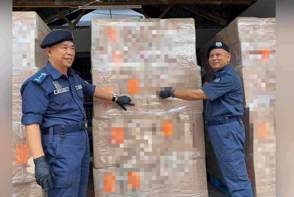 Wan Jamal Abdul Salam (kiri) menunjukkan kesan lumpur pada kotak rokok seludup yang dibawa masuk melalui negara jiran menggunakan laluan laut.
