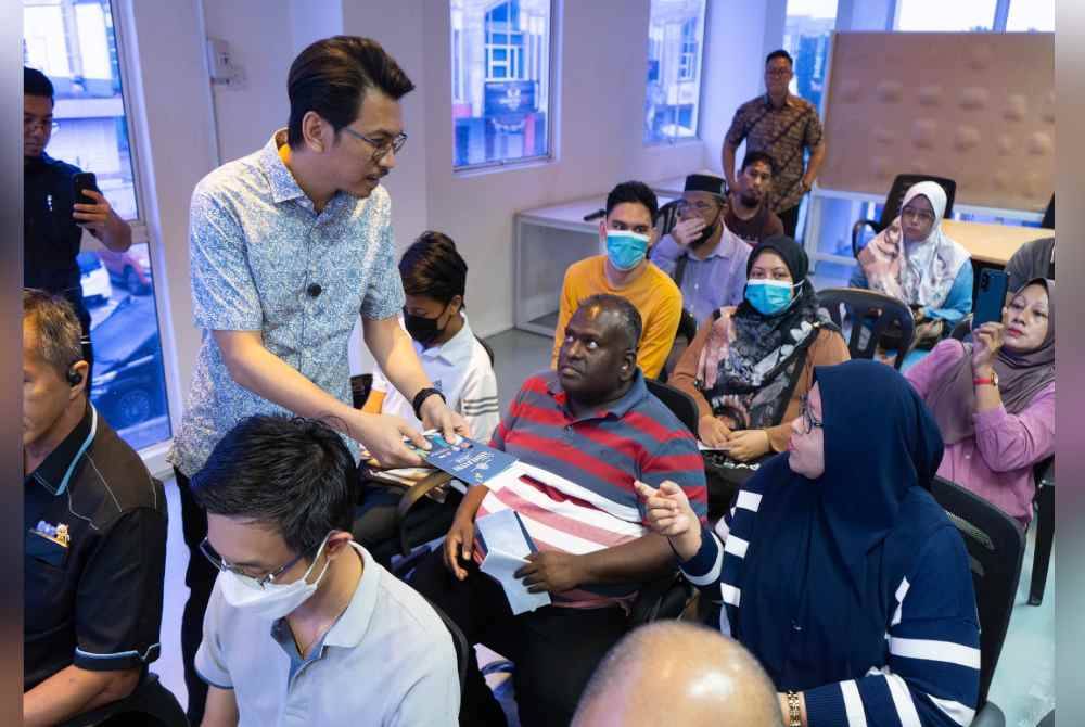 Muhammad Kamil menyampaikan bantuan tunai kepada 17 peniaga yang terkesan akibat kebakaran di Pasar Raya Besar Mydin di Manjoi, Perak. Foto Facebook Anwar Ibrahim