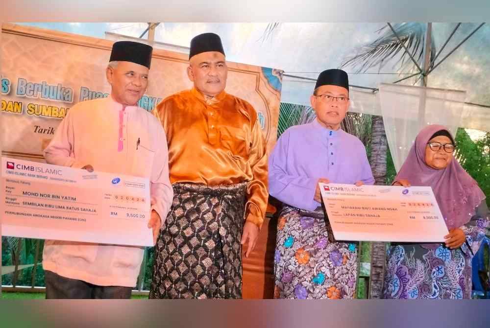 Abdul Fattah (dua dari kanan) dan Mohamad Hanifah (dua dari kiri) bersama mantan jawatankuasa Angkasa yang menerima sumbangan duit raya daripada Angkasa.