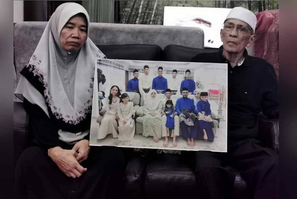 Megat Khashusaini (kanan) dan Nor Hanita Meor Mohd Nor, 62, datuk dan nenek Megat Ashman Aqif, pelajar Malaysia yang terkorban dalam kemalangan jalan raya di Tasik Tekapo, New Zealand menunjukkan potret keluarga ketika ditemui di kediaman mereka di Gunung Rapat pada Ahad. Foto Bernama