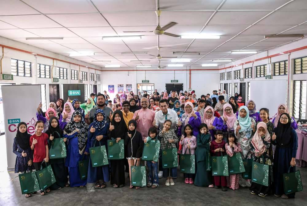 Jay Khairil (tengah) bergambar bersama penerima-penerima sumbangan baju raya pada Majlis Penyerahan Sumbangan Baju Raya kepada Komuniti PPR Lembah Subang di Dewan Blok D, PPR Lembah Subang pada Rabu. Turut sama Pengarah Eksekutif Woman of Will (WOW), Lakshwin Muruga dan Ketua Pemimpin Wanita WOW Sewing Centre, Isham Romli. Foto Bernama