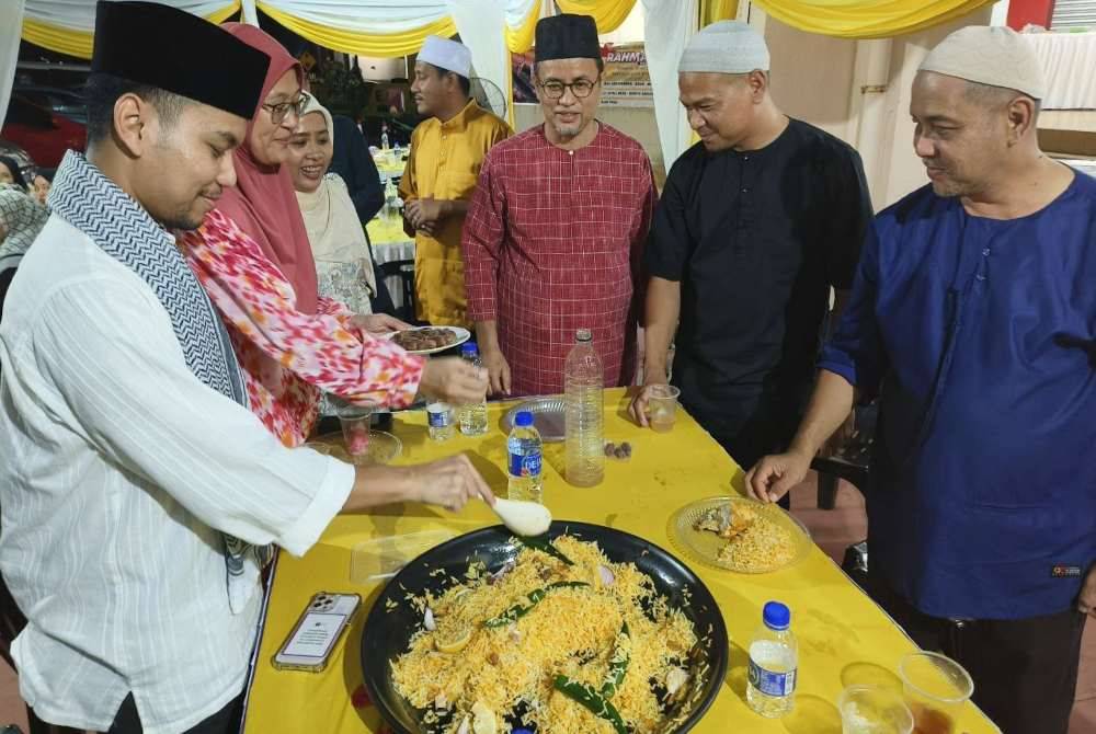 Azman (tiga dari kanan) beramah mesra dengan kakitangan KPDN Kelantan semasa majlis iftar di Kota Bharu pada Rabu.