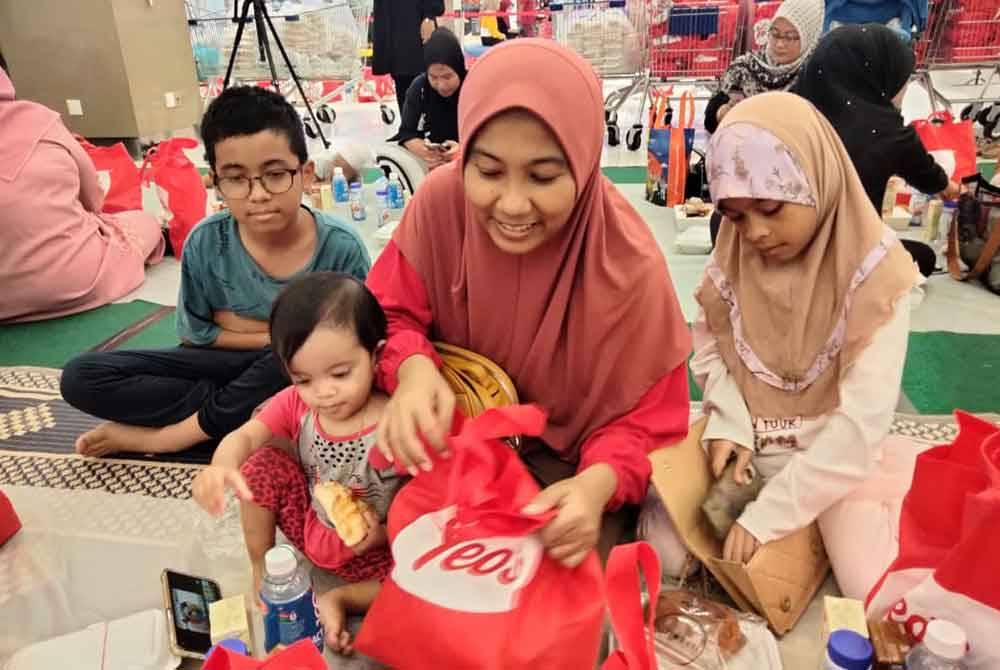 Noor Hafiza melihat hidangan yang disediakan kepada pengunjung Mydin yang menyertai Iftar Ala Madinah di Mydin Tunjong pada Rabu.