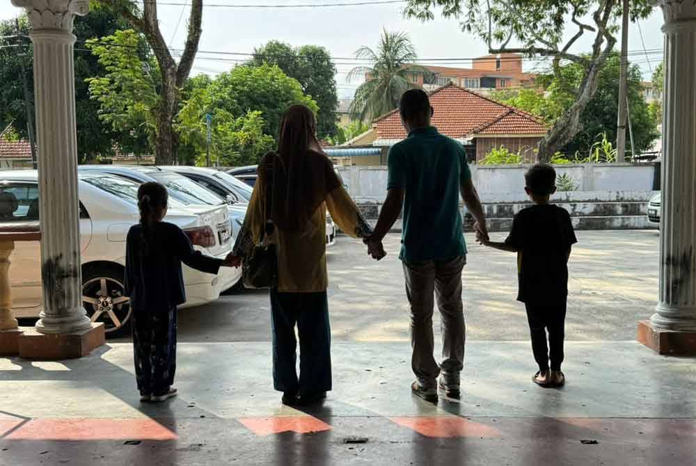 Jali berpimpinan tangan dengan isteri dan dua anaknya untuk pulang ke rumah mereka di Butterworth selepas dibebaskan dari Penjara Reman Pulau Pinang.