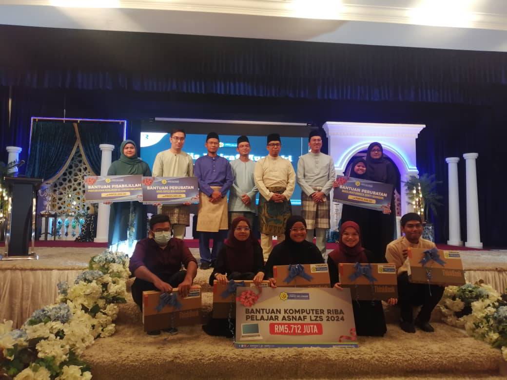 Ahmad Fadhil (empat dari kanan) bergambar bersama penerima zakat pada Majlis Iftar bersama Muzakki dan Penyerahan Zakat Ramadan 2024 di Dewan Orkid, Wisma PKPS pada Rabu.

