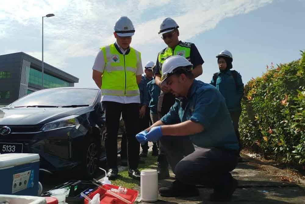 Tian Soon (berdiri, kiri) melihat kerja-kerja persampelan dilakukan.