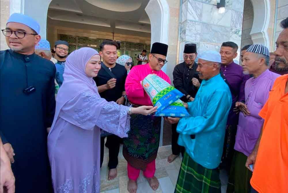 Madammu (dua dari kiri) bersama Azizan (tiga dari kiri) menyampaikan sumbangan beras kepada penerima.