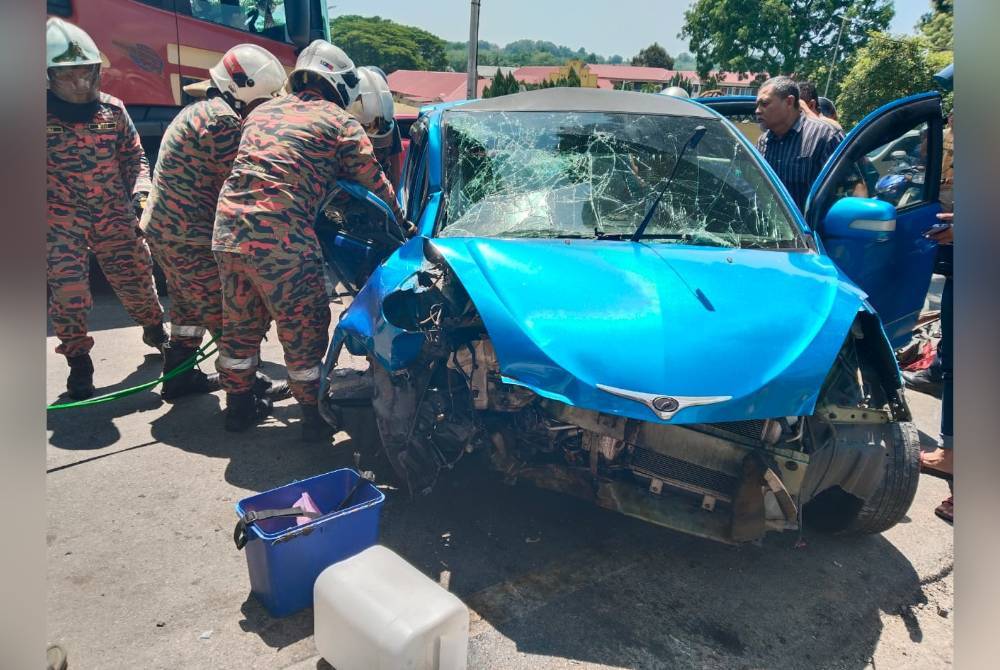Anggota bomba berjaya mengeluarkan mayat mangsa yang tersepit di tempat pemandu selepas kenderaannya terbabas dan melanggar pokok.