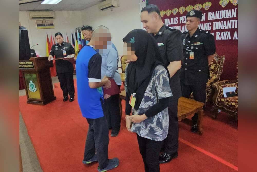 Din ketika diiringi isterinya ketika mengambil sijil pelepasan keluar daripada Penjara Pusat menerusi program PBSL di Dewan Mini Penjara Pusat Kota Kinabalu.