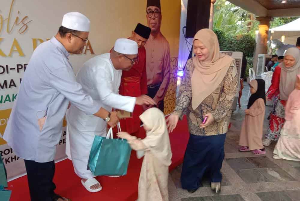 Yahya ketika menyampaikan sumbangan kepada anak-anak yatim pada majlis iftar dikediamannya di Putatan.