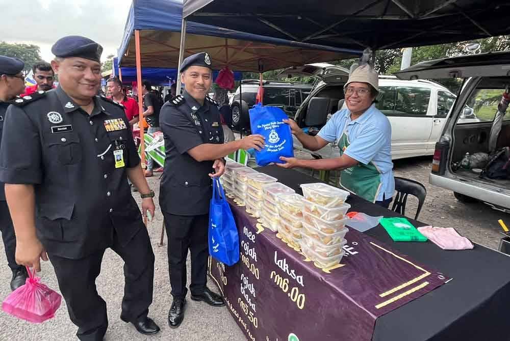 Pegawai IPD Klang Utara turun padang mengedarkan risalah berkaitan pencegahan jenayah di sekitar Bazar Ramadan Jalan Paip di Meru pada petang Khamis.