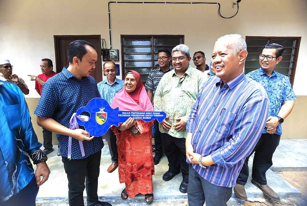 Suhaimi menyerahkan replika kinci kepada Zainab. Turut kelihatan Mohd Zamri