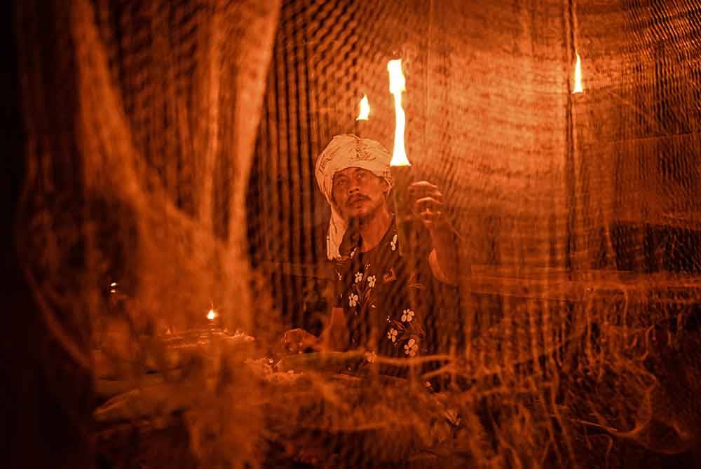Mohd Zailani Mohd Nor, 49, menyalakan pelita kekabu sebagai persiapan sempena malam tujuh likur semasa ditemui di rumahnya di Kampung Alor Belanga, semalam.
