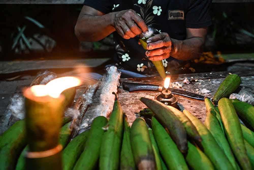 Proses membuat pelita kekabu sebagai persiapan sempena malam tujuh likur semasa ditemui di rumahnya di Kampung Alor Belanga, semalam.