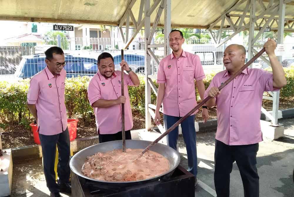 Yahanis (dua dari kiri) bersama pegawai kanan Perak SADC mengacau rendang sempena Rewang Ramadan Kakitangan Perak SADC di pekarangan parkir Ibu Pejabat Perak SADC di sini pada Khamis.