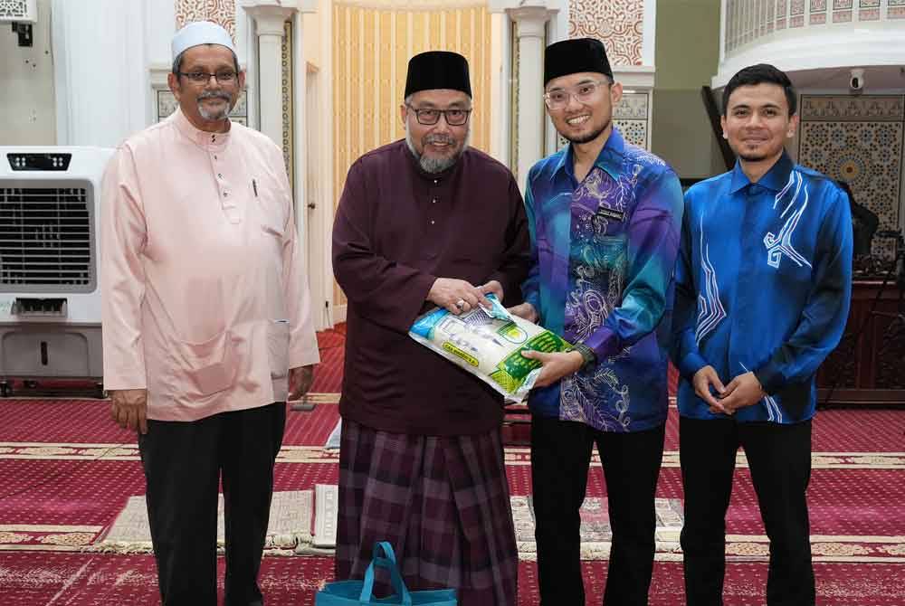 Mohd Radzif menyerahkan bantuan ‘food bank’ kepada salah seorang penerima.